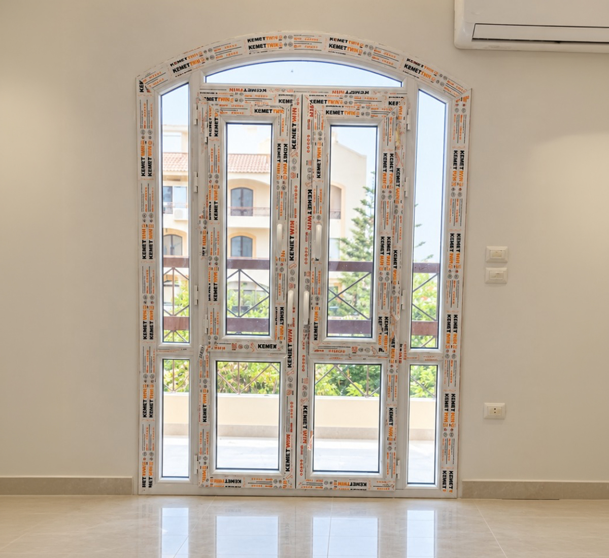 باب UPVC أبيض مفصلي بزجاج ومفتوح على بلكونة